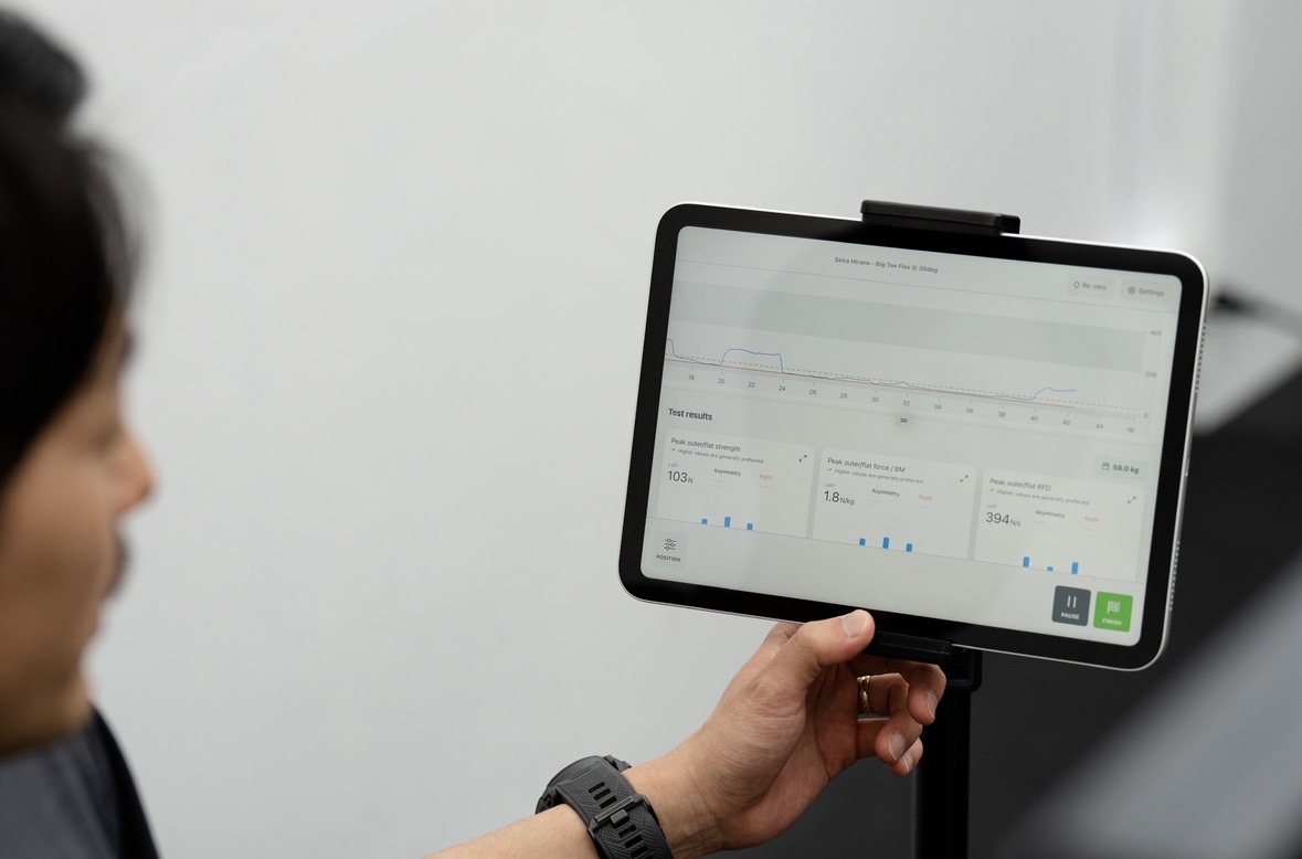 トレーナーがタブレットで測定結果を確認する様子