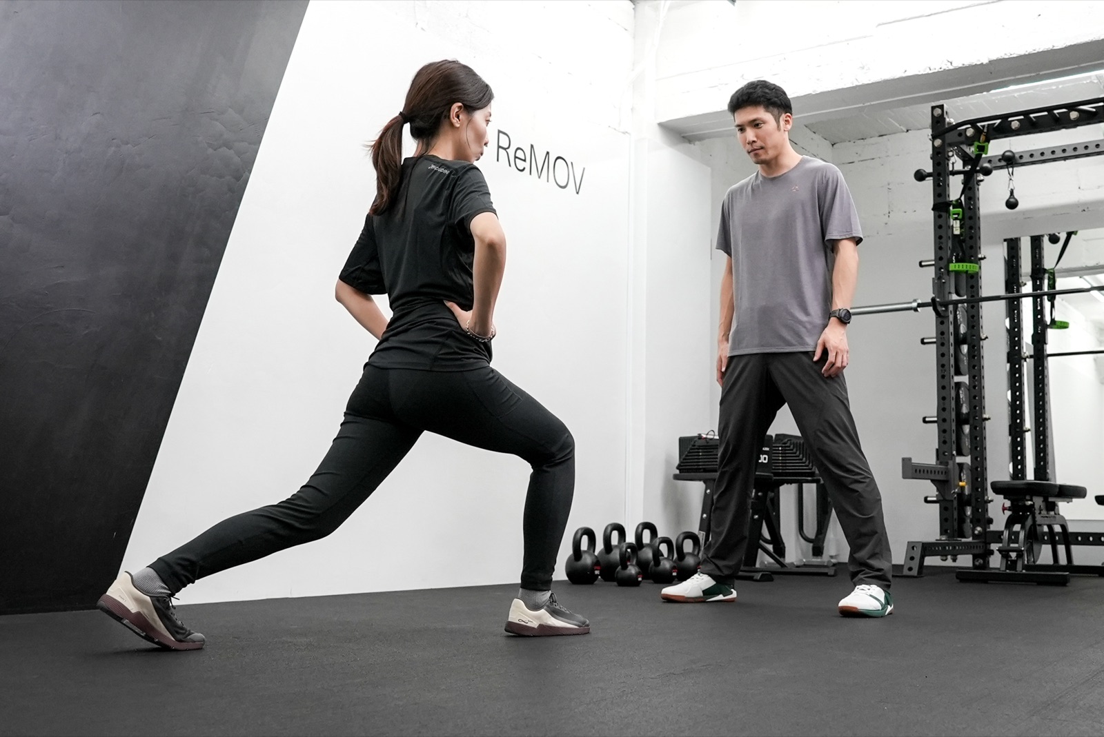 トレーナーがランジのフォームを確認する様子